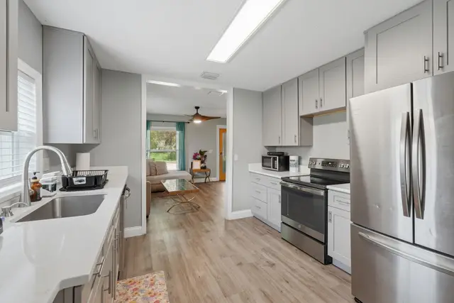 Bright modern kitchen with stainless appliances and open living view at Fruit Tree Home