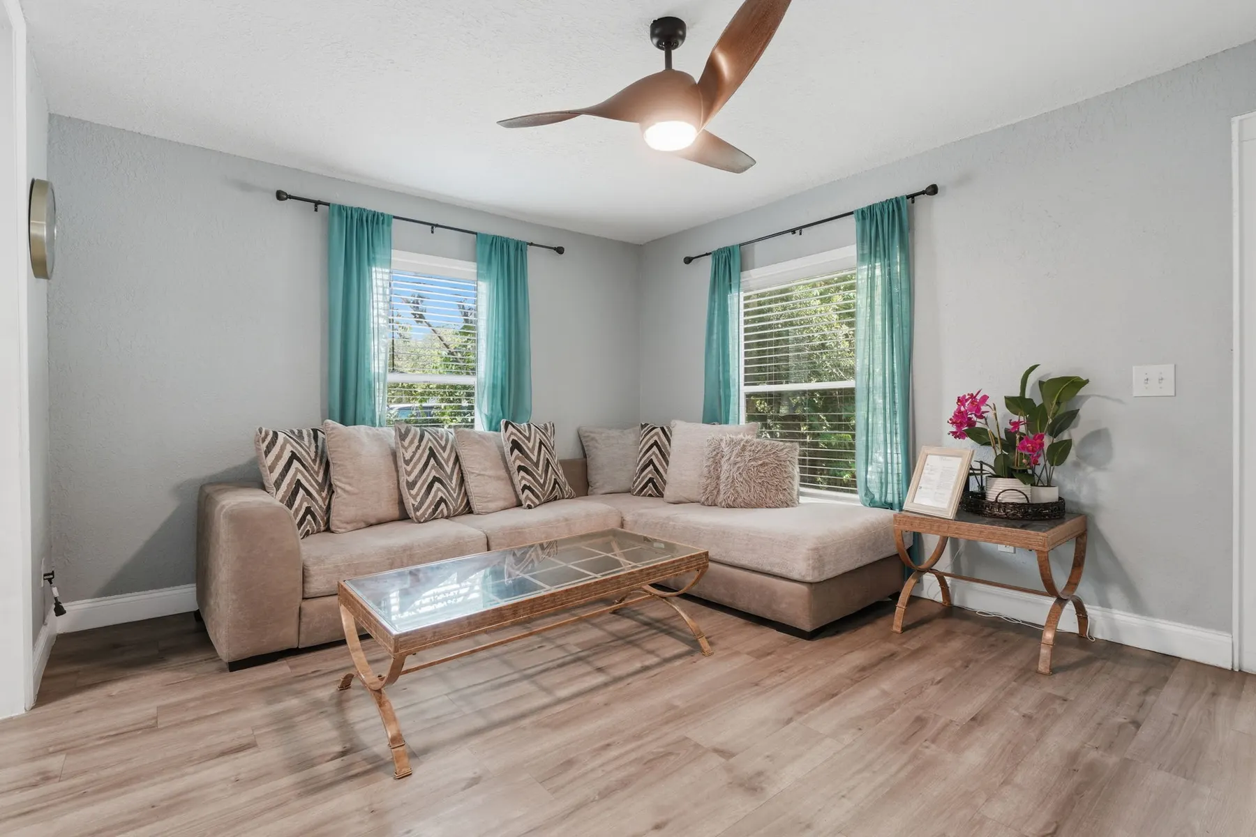 Bright, modern living room with cozy sectional and abundant natural light at Fruit Tree Home