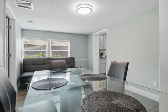 Bright dining area with glass table, bench seating, and natural light at Fruit Tree Home
