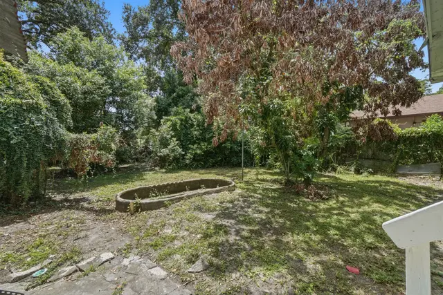 Private backyard with mature trees and peaceful shaded green space at Fruit Tree Home