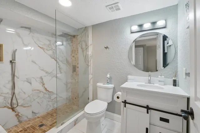Bright modern bathroom with sleek glass shower and elegant finishes at Fruit Tree Home