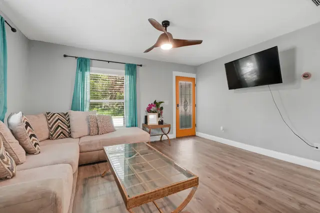Bright living room with sectional, smart TV, and vibrant designer touches at Fruit Tree Home
