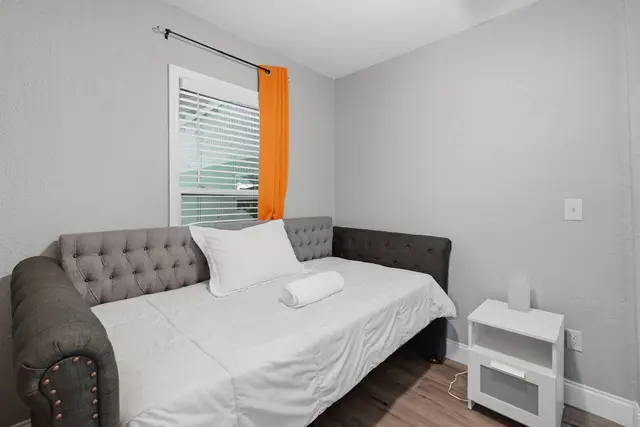 Cozy modern daybed nook with bright window and bedside storage at Fruit Tree Home