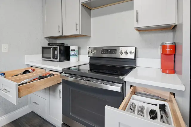 Modern kitchen with organized drawers, coffee maker, and sleek finishes at Fruit Tree Home