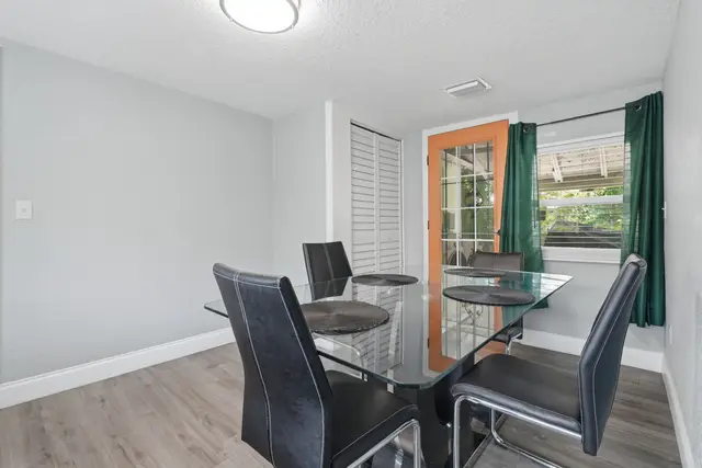 Bright modern dining area with glass table and outdoor access at Fruit Tree Home