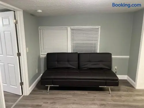 Modern futon lounge with clean finishes and flexible extra sleeping space at Fruit Tree Home