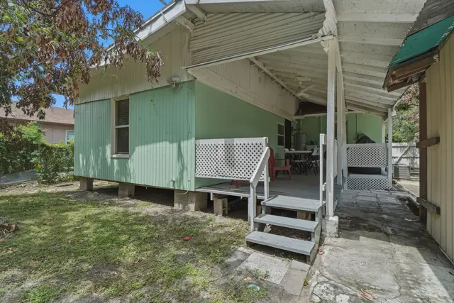 Covered side porch with shaded outdoor seating and easy access at Fruit Tree Home