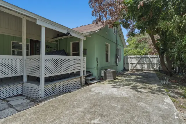 Private fenced patio with covered porch and roomy outdoor space at Fruit Tree Home