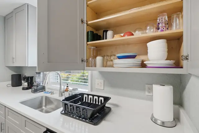 Bright kitchen with stocked cabinets, coffee maker, and sunny sink area at Fruit Tree Home