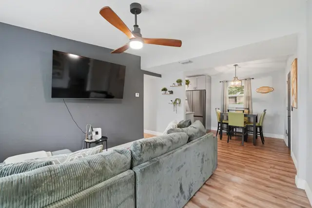 Open living space with large TV, comfy seating, and dining area at Amelia’s Arena Retreat