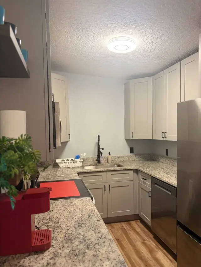 Modern kitchen with granite counters, stainless appliances, and coffee station at Amelia’s Arena Retreat