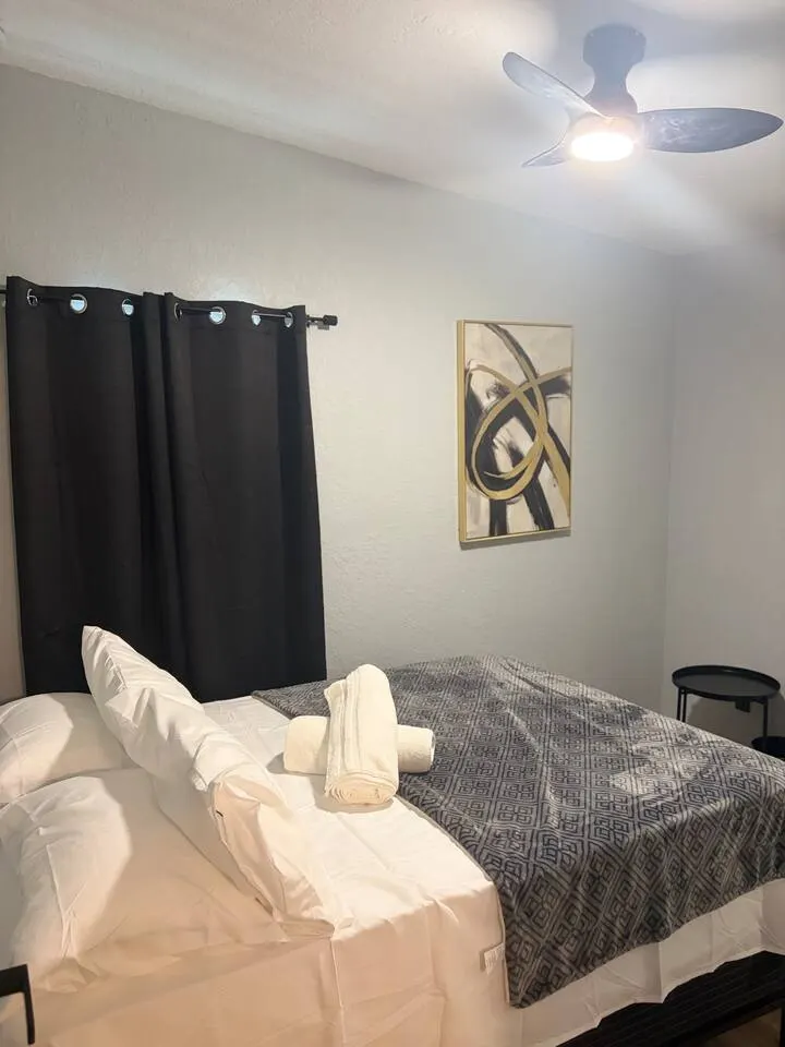 Cozy modern bedroom with blackout curtains and fresh linens at Amelia’s Arena Retreat, a Libema home in Orlando