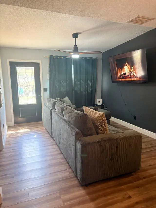 Cozy modern lounge with plush seating, fireplace TV, and stylish finishes at Amelia’s Arena Retreat
