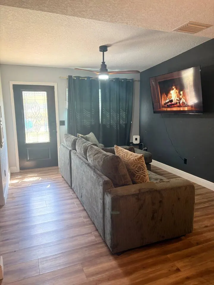Cozy modern lounge with plush seating, fireplace TV, and stylish finishes at Amelia’s Arena Retreat, a Libema home in Orlando