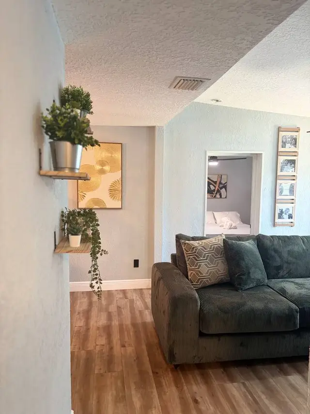 Cozy living room with plush seating, warm floors, and stylish modern decor at Amelia’s Arena Retreat