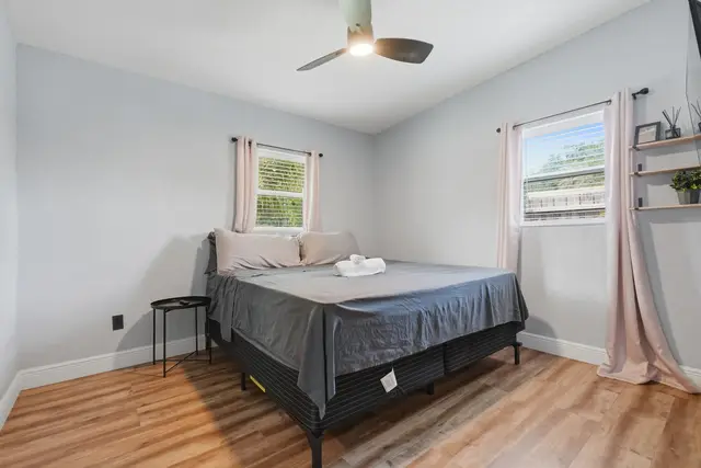 Bright minimalist bedroom with natural light and a cozy king bed at Amelia’s Arena Retreat