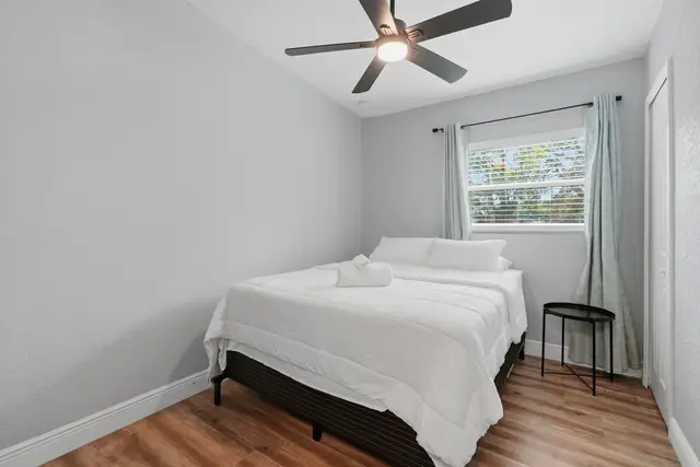 Bright, cozy bedroom with crisp linens, natural light, and ceiling fan at Amelia’s Arena Retreat