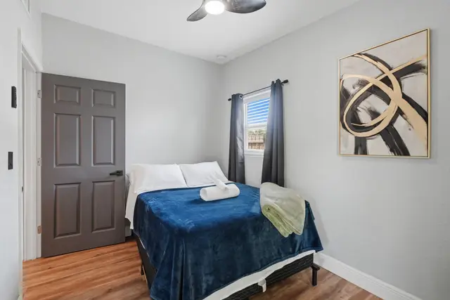 Cozy modern bedroom with soft linens, blackout curtains, and stylish decor at Amelia’s Arena Retreat