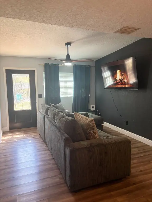 Cozy living room with sectional, smart TV, and stylish accent wall at Amelia’s Arena Retreat