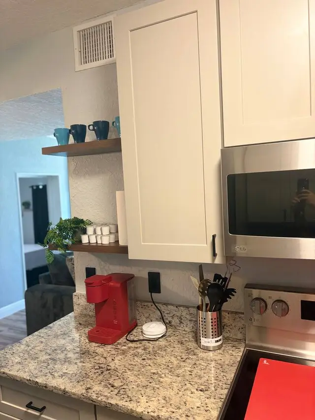 Modern kitchen with granite counters, coffee station, and stainless appliances at Amelia’s Arena Retreat