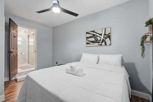 Bright modern bedroom with en-suite bath and crisp hotel-style linens at Amelia’s Arena Retreat