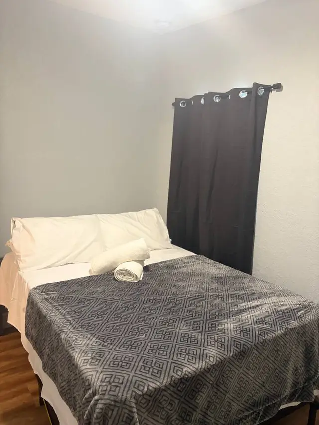 Cozy bedroom with fresh linens and blackout curtains at Amelia’s Arena Retreat