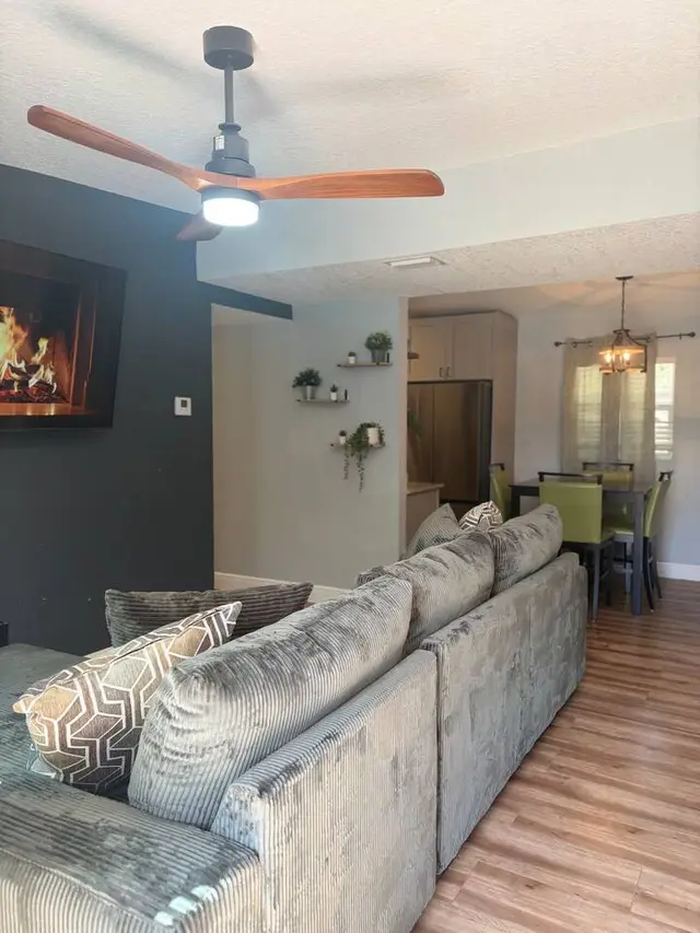 Cozy open living space with fireplace feature and bright dining area at Amelia’s Arena Retreat