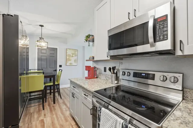 Bright modern kitchen with stainless appliances and cozy dining area at Amelia’s Arena Retreat