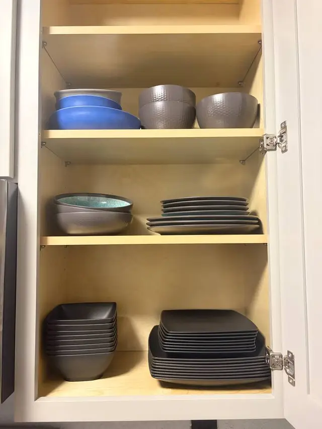 Well-stocked kitchen cabinet with organized modern dishware at Amelia’s Arena Retreat