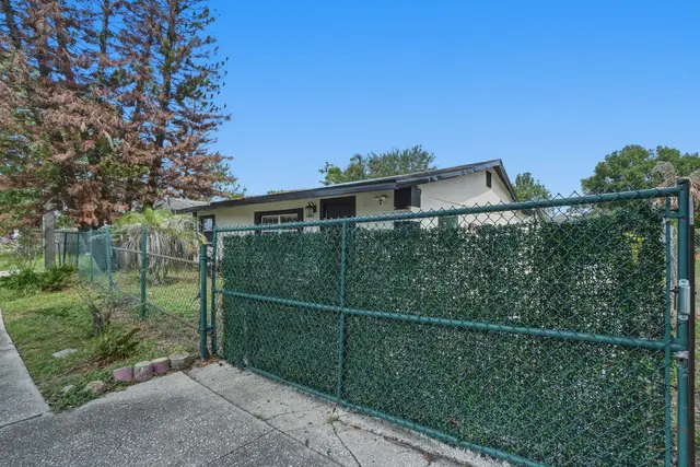 Private fenced yard with gated entry and mature trees at Piedmont