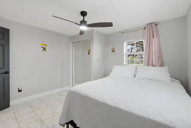 Bright, cozy bedroom with natural light, ceiling fan, and crisp white linens at Piedmont