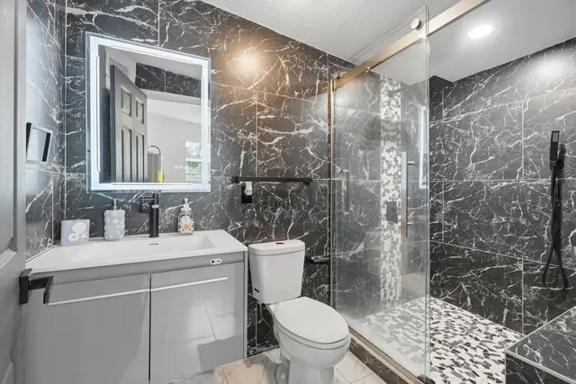 Stylish spa-like bathroom with glass shower and modern black finishes at Piedmont