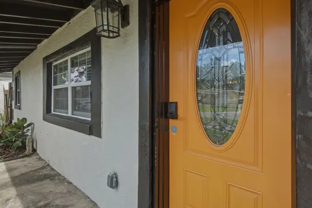 Bright statement entry with covered walkway and stylish glass front door at Piedmont