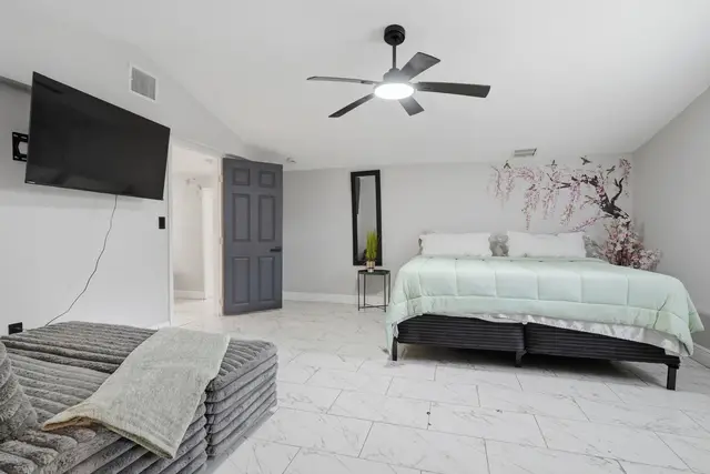 Spacious king bedroom with vaulted ceilings, TV, and stylish floral wall at Piedmont