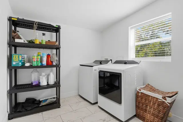 Bright laundry room with full-size washer, dryer, and handy storage at Piedmont