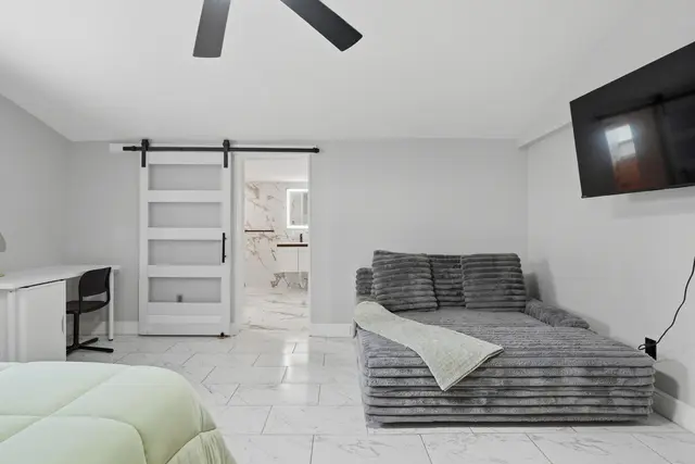 Bright modern bedroom with lounge chaise, workspace, and en suite bath at Piedmont