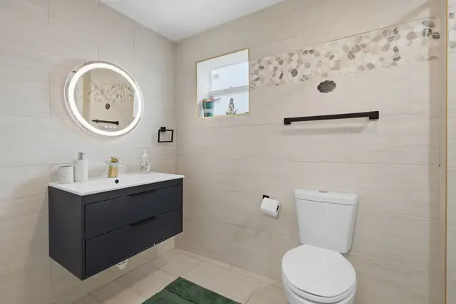 Modern spa-style bathroom with backlit mirror and sleek finishes at Piedmont