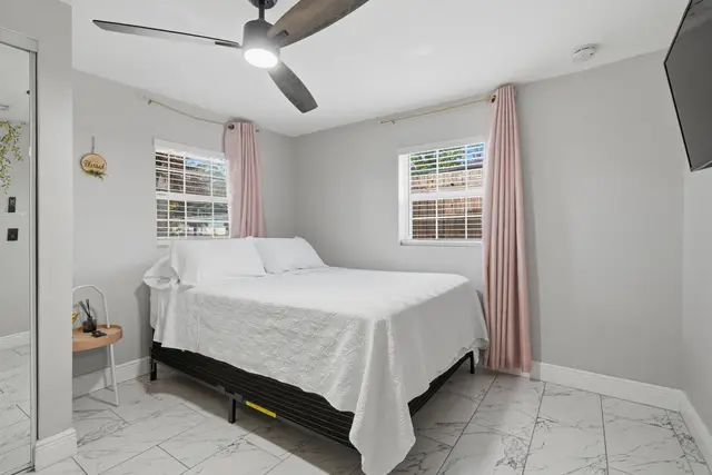 Bright, modern bedroom with natural light, TV, and cooling ceiling fan at Piedmont