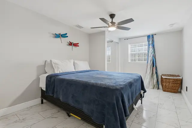 Bright, airy bedroom with a cozy bed, ceiling fan, and cheerful decor at Piedmont