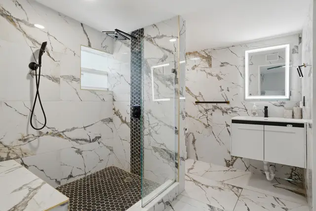 Spa-like marble bathroom with glass walk-in shower and modern vanity at Piedmont