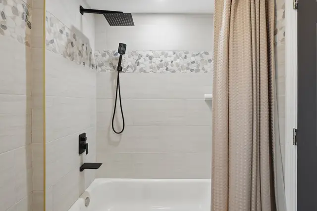 Modern tub-shower with rainfall head and stylish tile accents at Piedmont