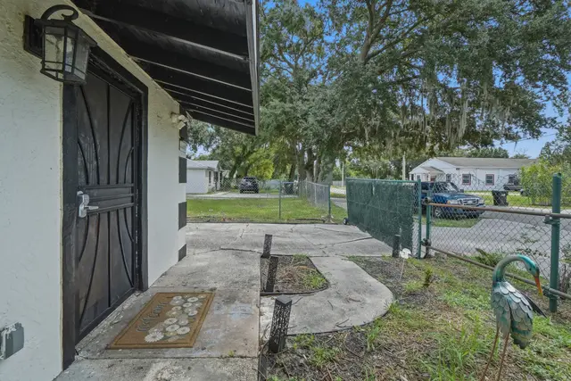 Private side entrance with fenced yard and shaded outdoor walkway at Piedmont
