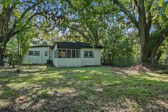 Private backyard retreat with screened porch and mature shade trees at Game Day Getaway-Downtown Orlando