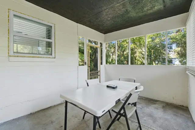 Screened porch with dining space and peaceful tree-lined views at Game Day Getaway-Downtown Orlando