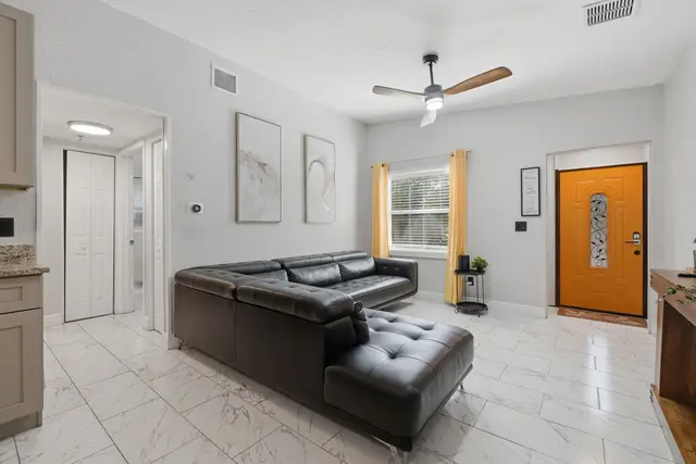 Bright modern living room with stylish sectional and bold entryway at Game Day Getaway-Downtown Orlando
