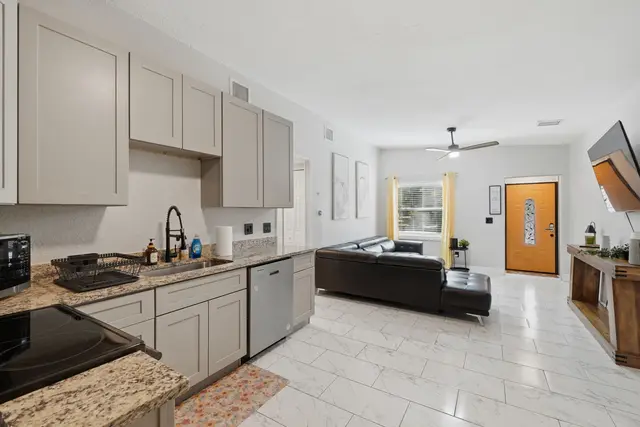 Bright open living space with modern kitchen and stylish yellow entry at Game Day Getaway-Downtown Orlando