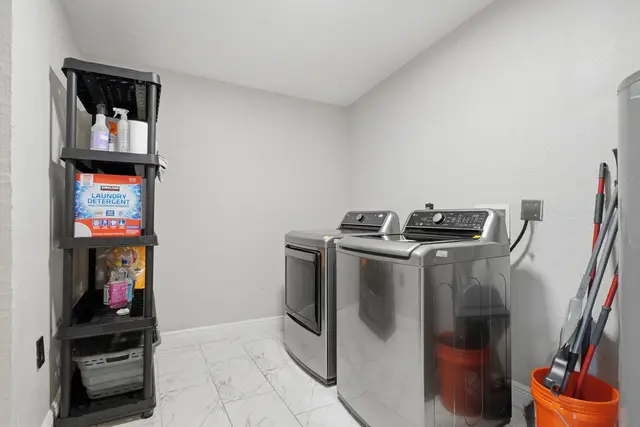 Modern in-home laundry room with washer, dryer, and stocked essentials at Game Day Getaway-Downtown Orlando