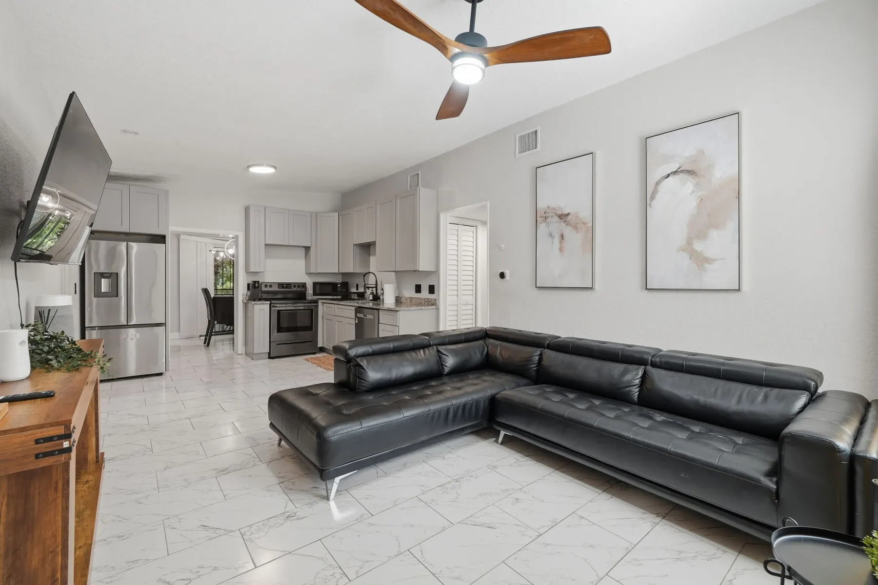 Bright open living space with modern kitchen and stylish sectional at Game Day Getaway-Downtown Orlando