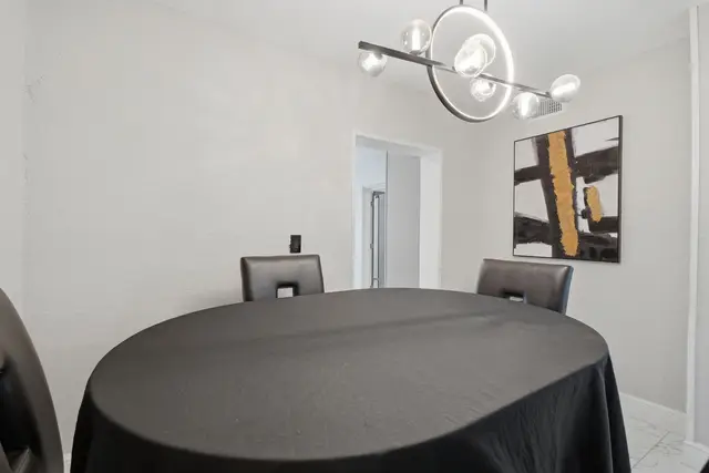 Modern dining nook with statement lighting and sleek contemporary style at Game Day Getaway-Downtown Orlando