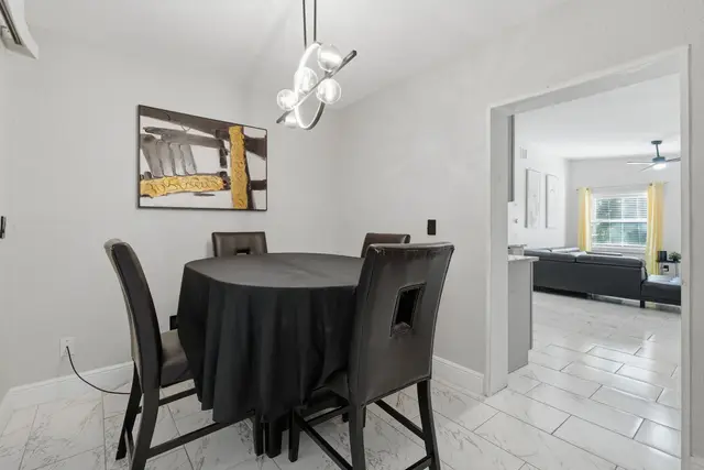 Modern dining nook with stylish lighting and open flow to living room at Game Day Getaway-Downtown Orlando